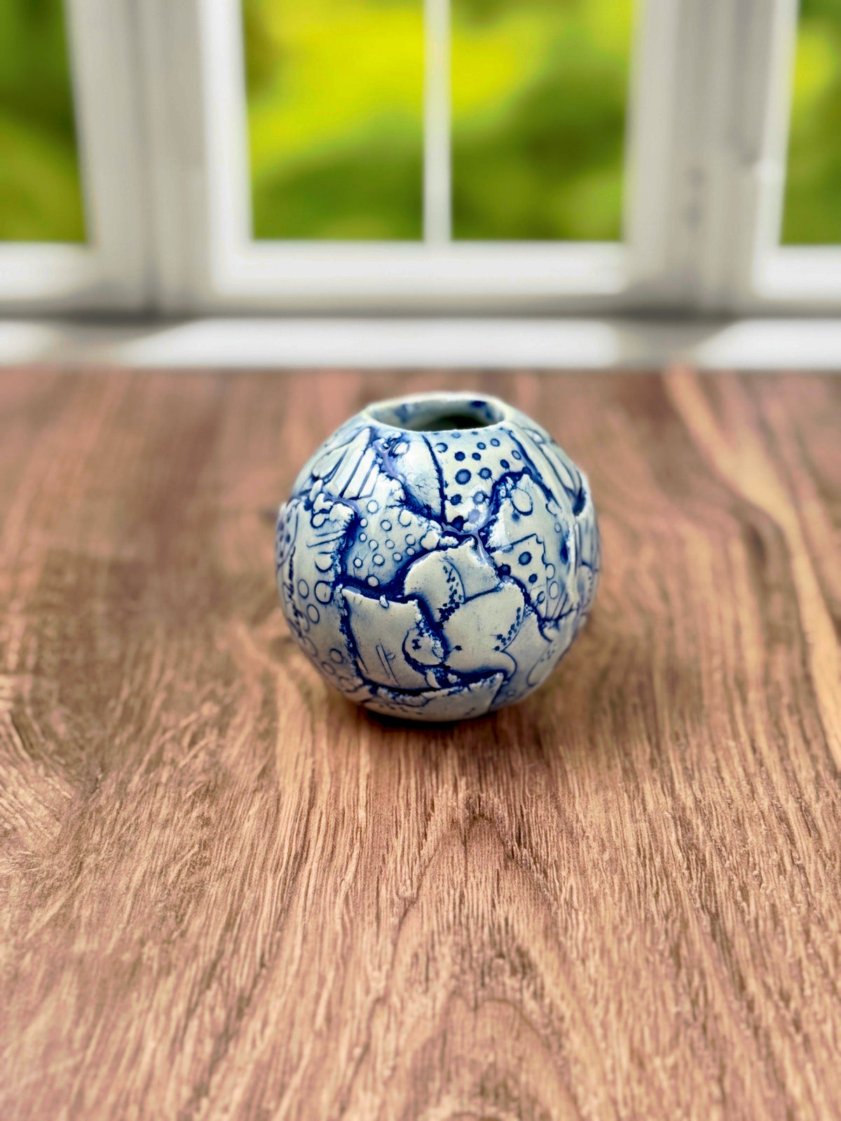 Small round blue bud vase with geometric and flower texture